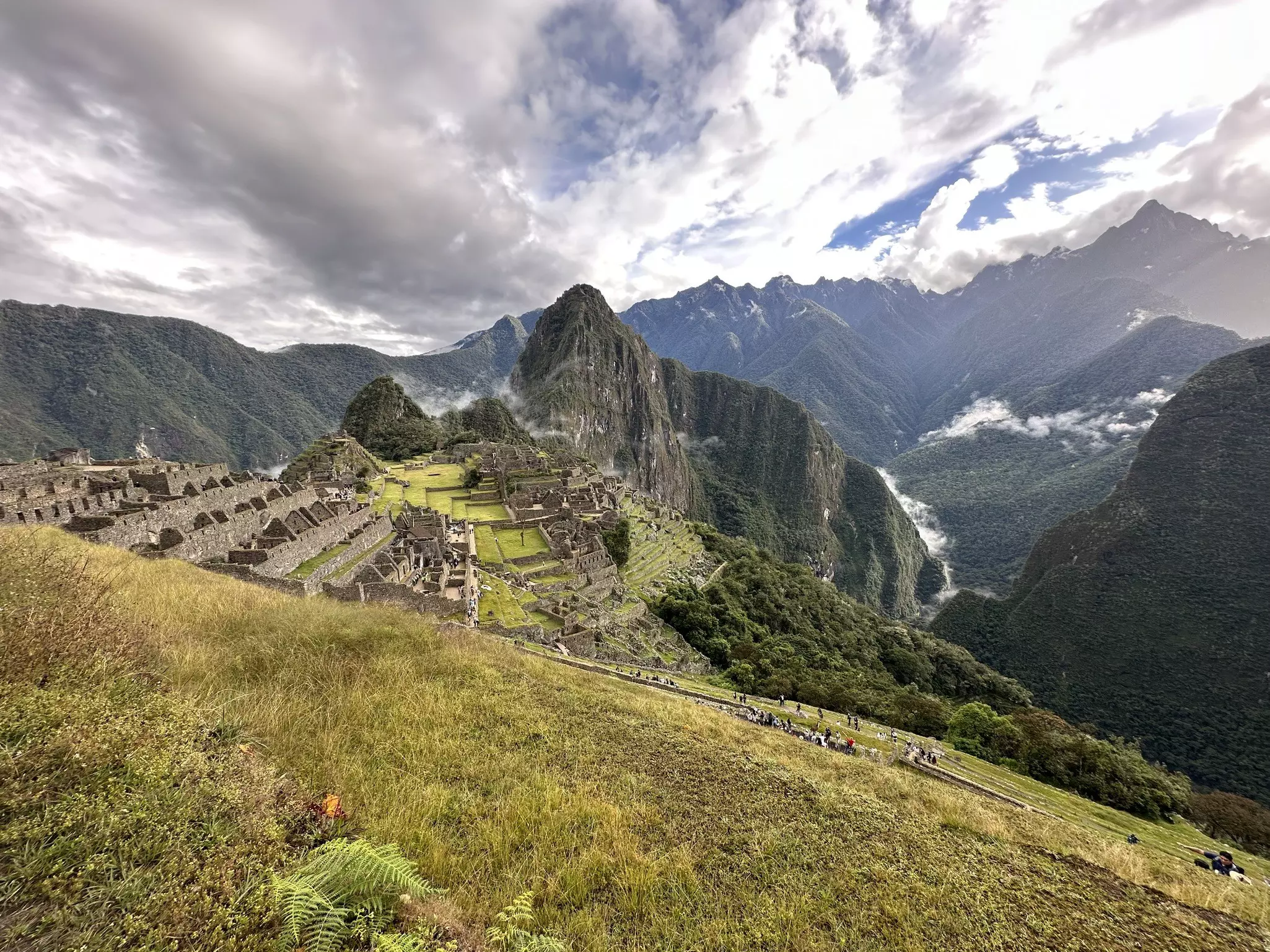 Stone architecture of Machu Picchu embedded in a grassy mountainside