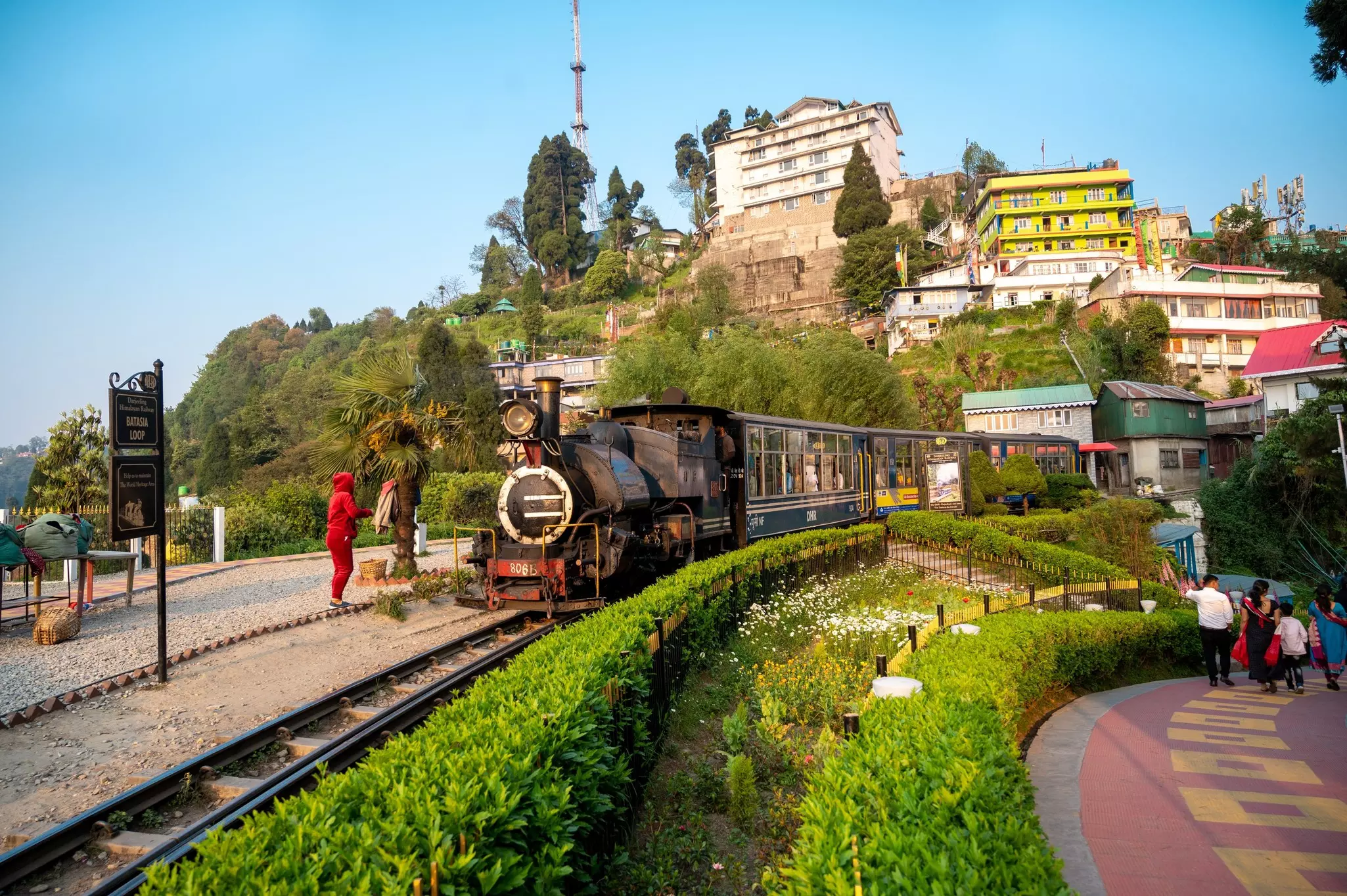 A small train engine on a narrow track in a mountain town.