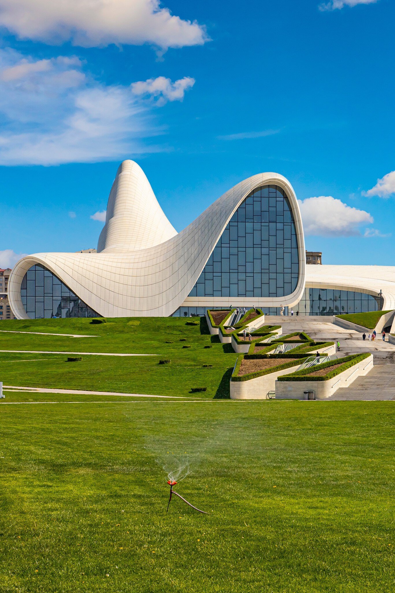 Exterior of modern cultural center in Baku, the capital of Azerbaijan. Blue sky and green lawn below.