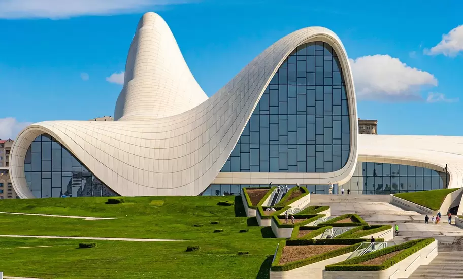 Exterior of modern cultural center in Baku, the capital of Azerbaijan. Blue sky and green lawn below.