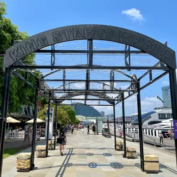 King Street Wharf Promenade in Darling Harbour. People walking along promenade and tourists and locals waiting to take a  cruise around the harbour. Sydney, Australia.