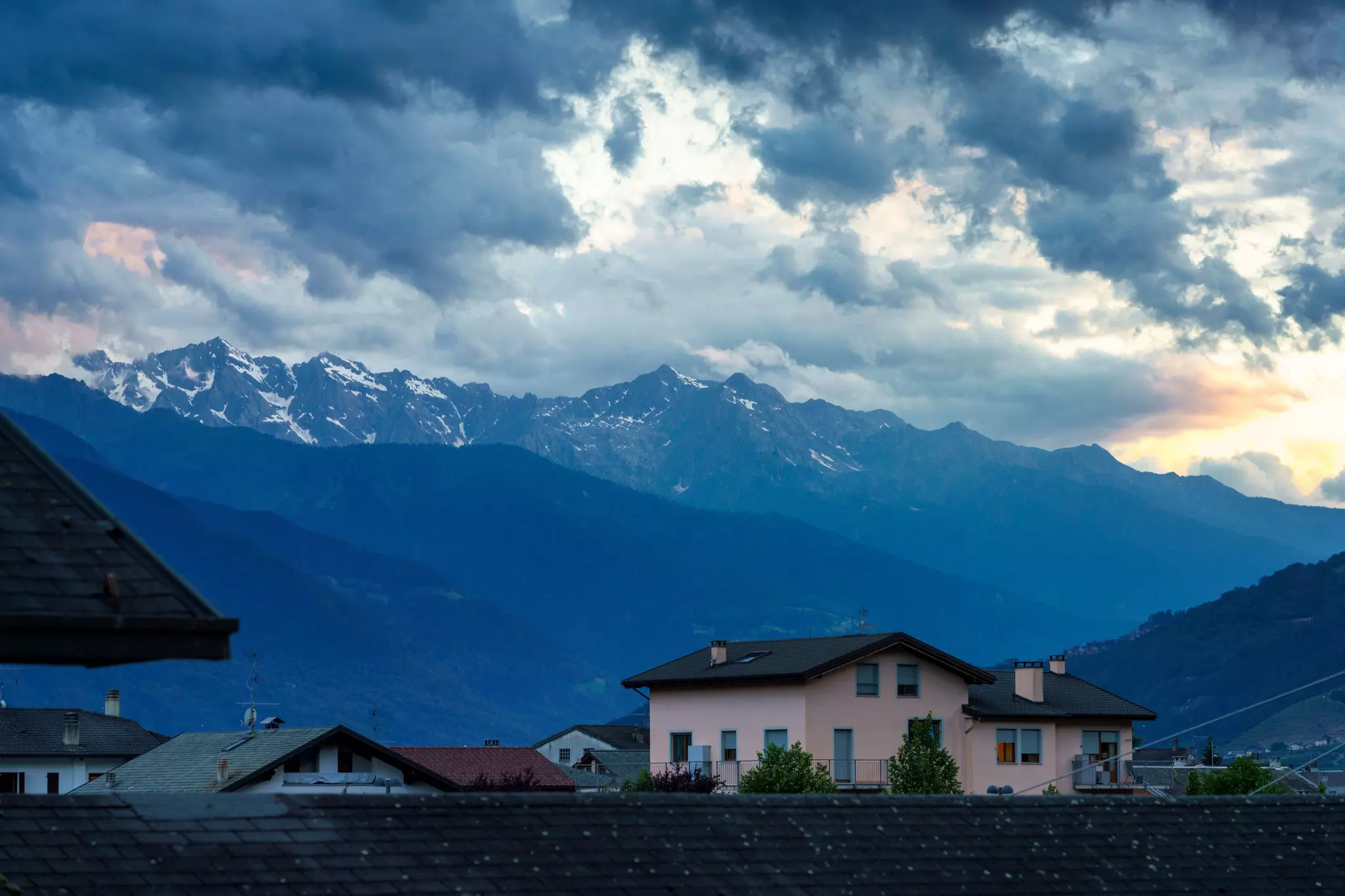 Tirano, Italy. Old houses along the Adda river with mountains in background.