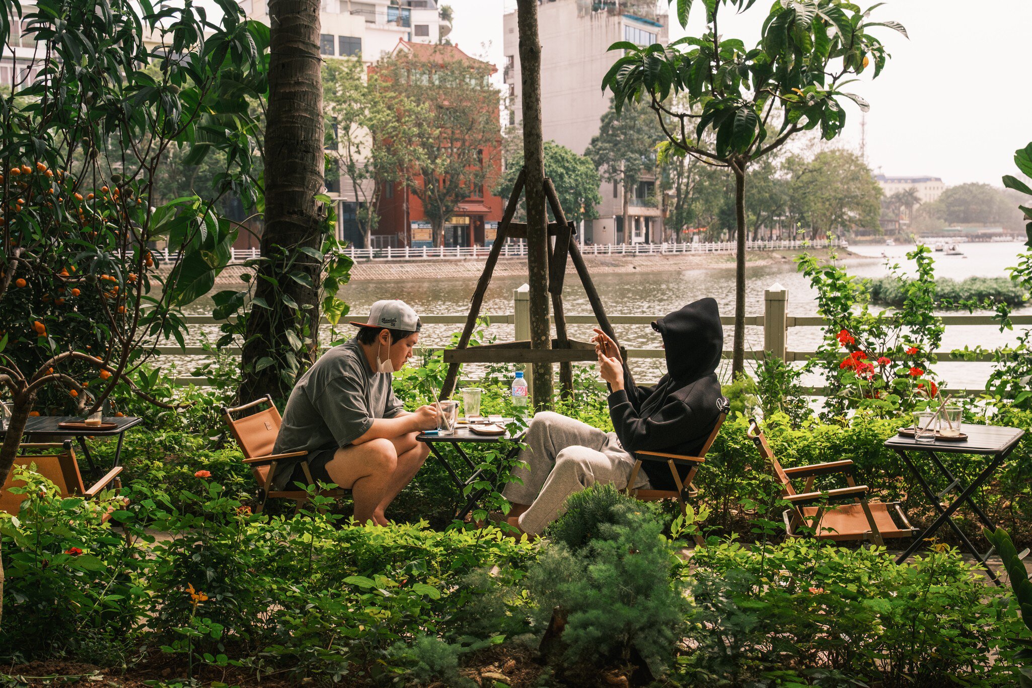 Two men enjoy a drink and relax at the cafe by Truc Bach Lake, Hanoi.