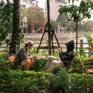 Two men enjoy a drink and relax at the cafe by Truc Bach Lake, Hanoi.