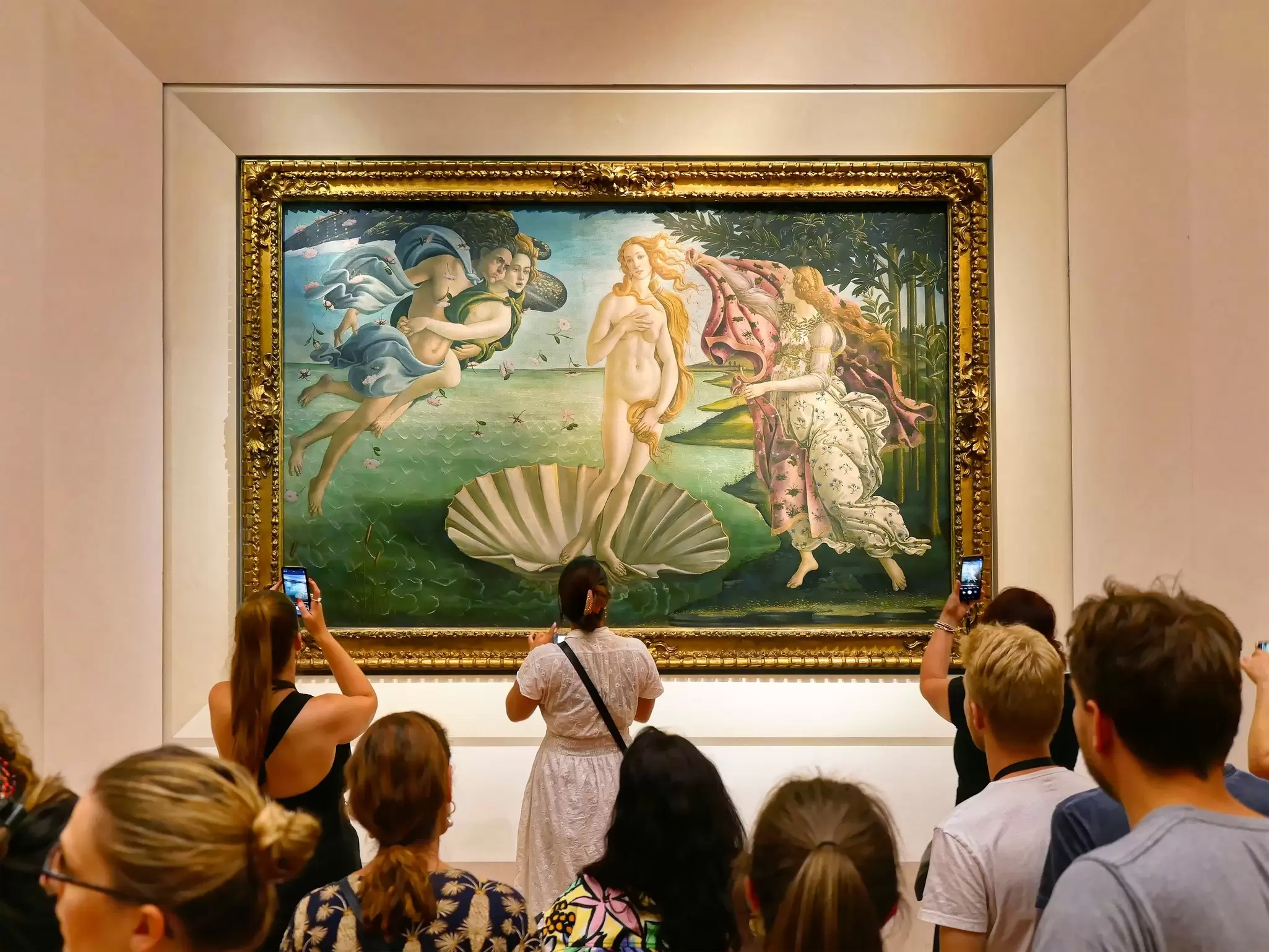 Visitors taking photos in front of 'The Birth of Venus' painting by Sandro Botticelli in the Galleria degli Uffizi in Florence, Italy.