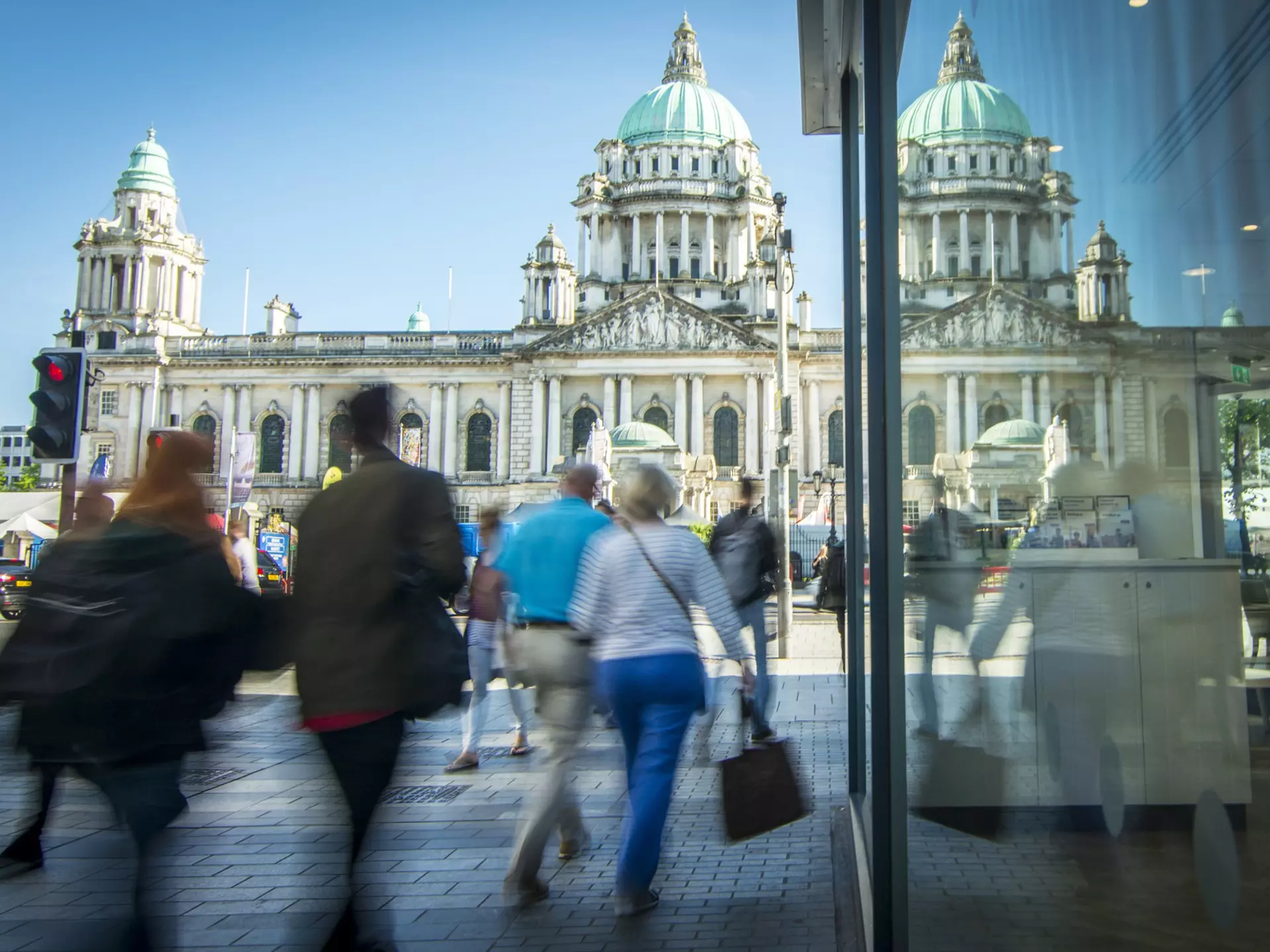 Motion blurred shoppers in front of Belfast city hall in Northern Ireland. William Barton / Getty Images
