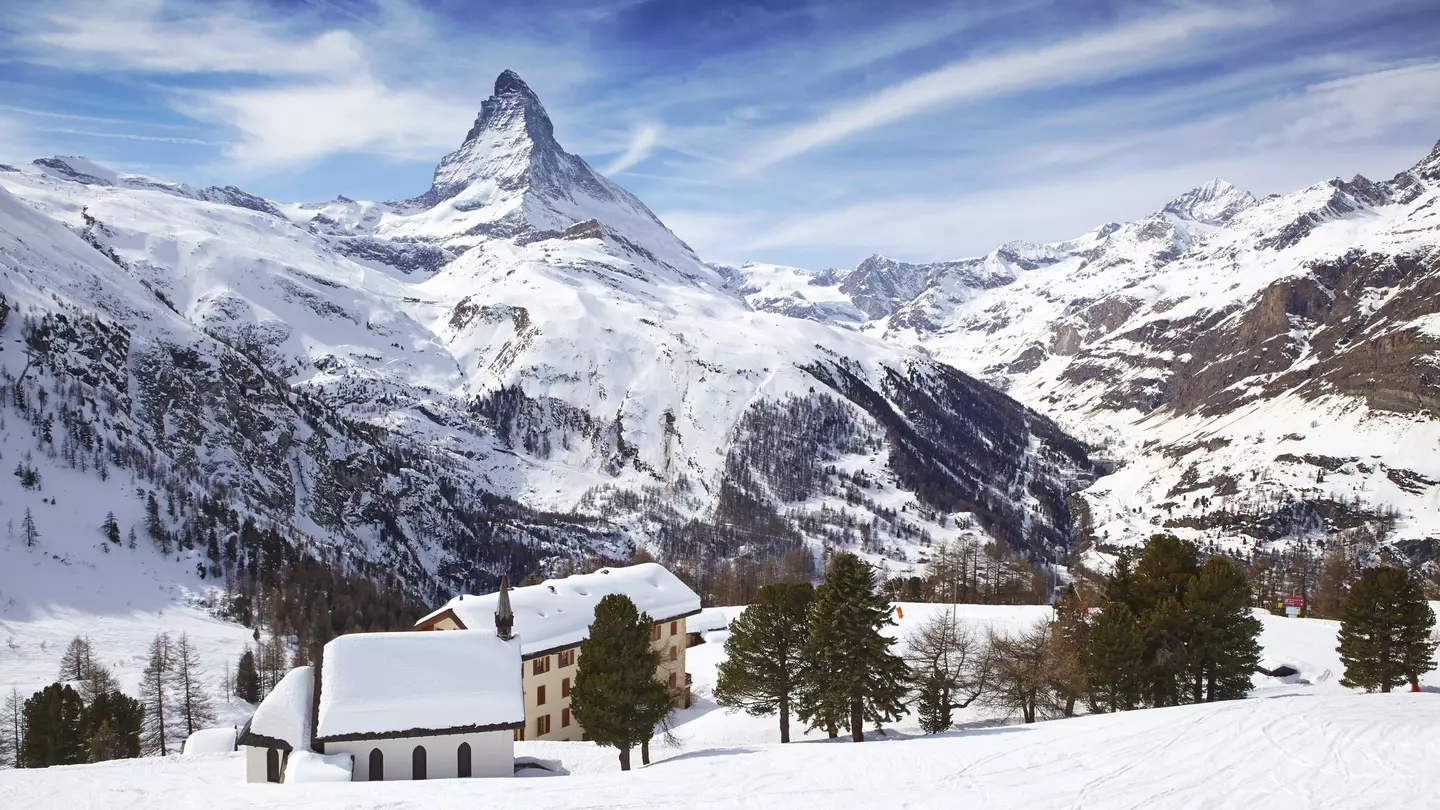 The Matterhorn rises over snowy rooftops near Zermatt in Switzerland.