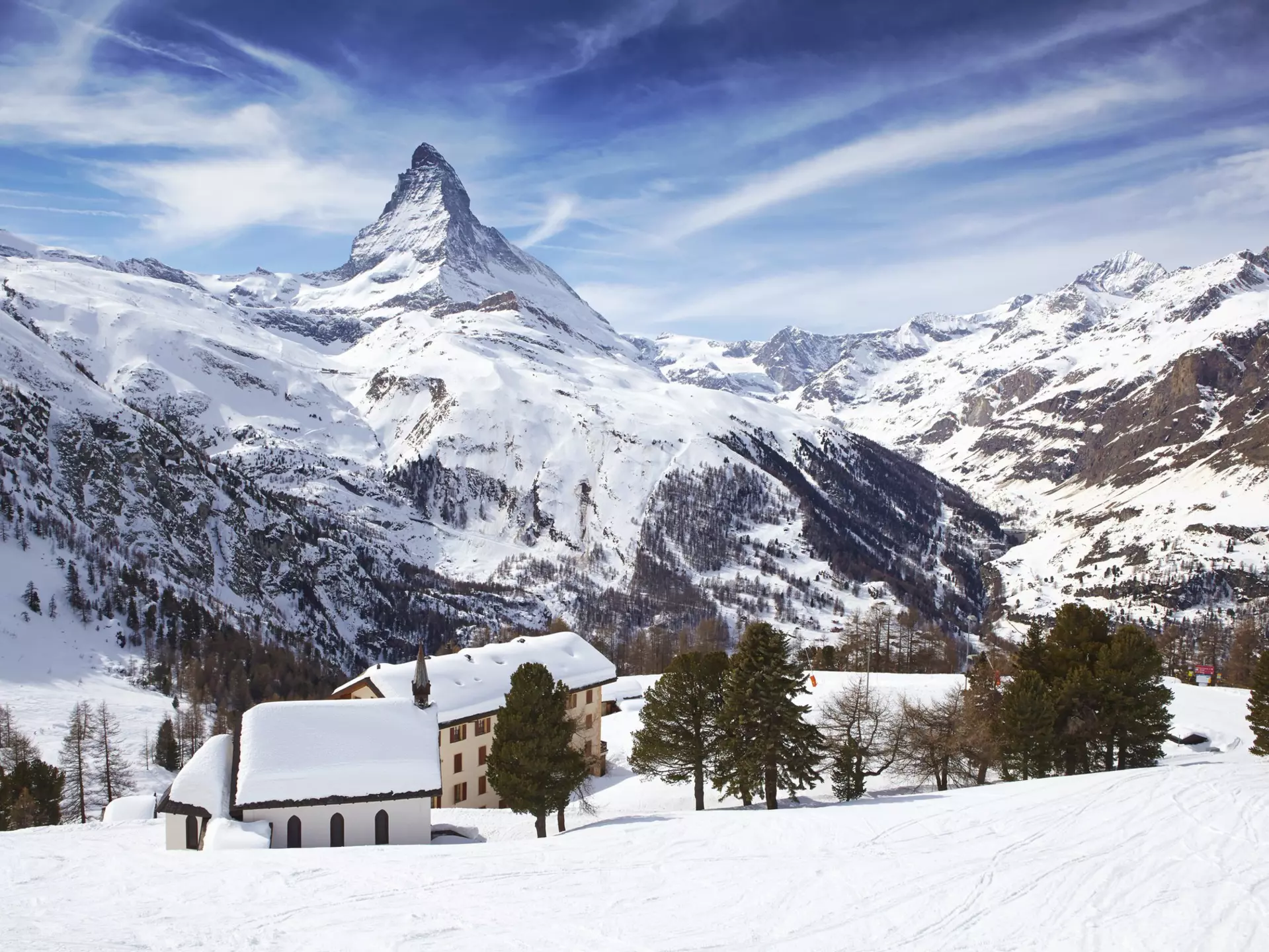 The Matterhorn rises over snowy rooftops near Zermatt in Switzerland.