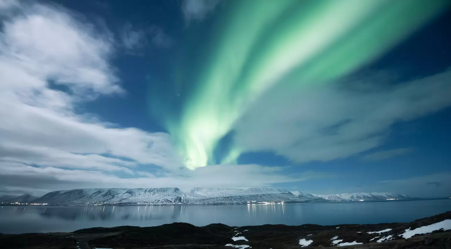 View of northern lights over the mountains in Akureyri, Iceland.