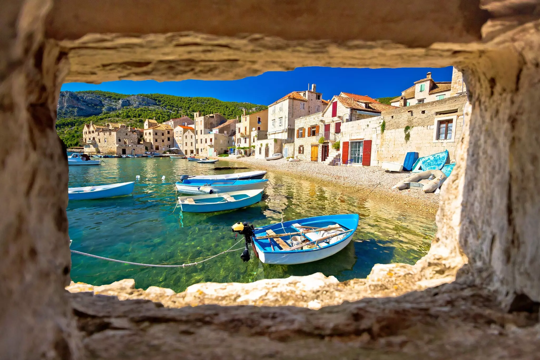 Boats moored next to a pebble beach in Croatia