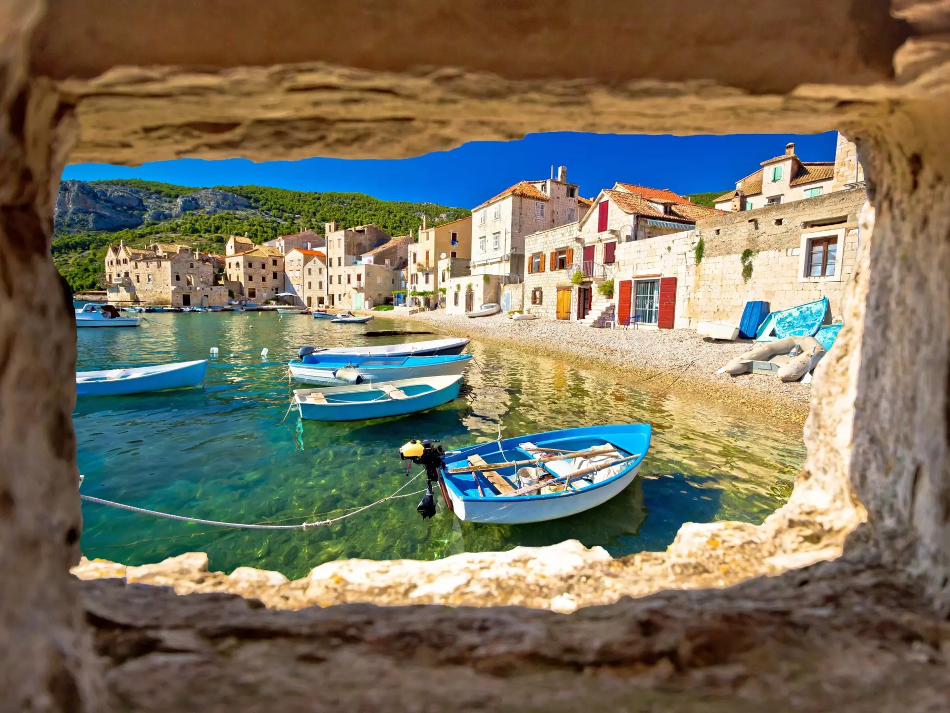 Boats moored next to a pebble beach in Croatia