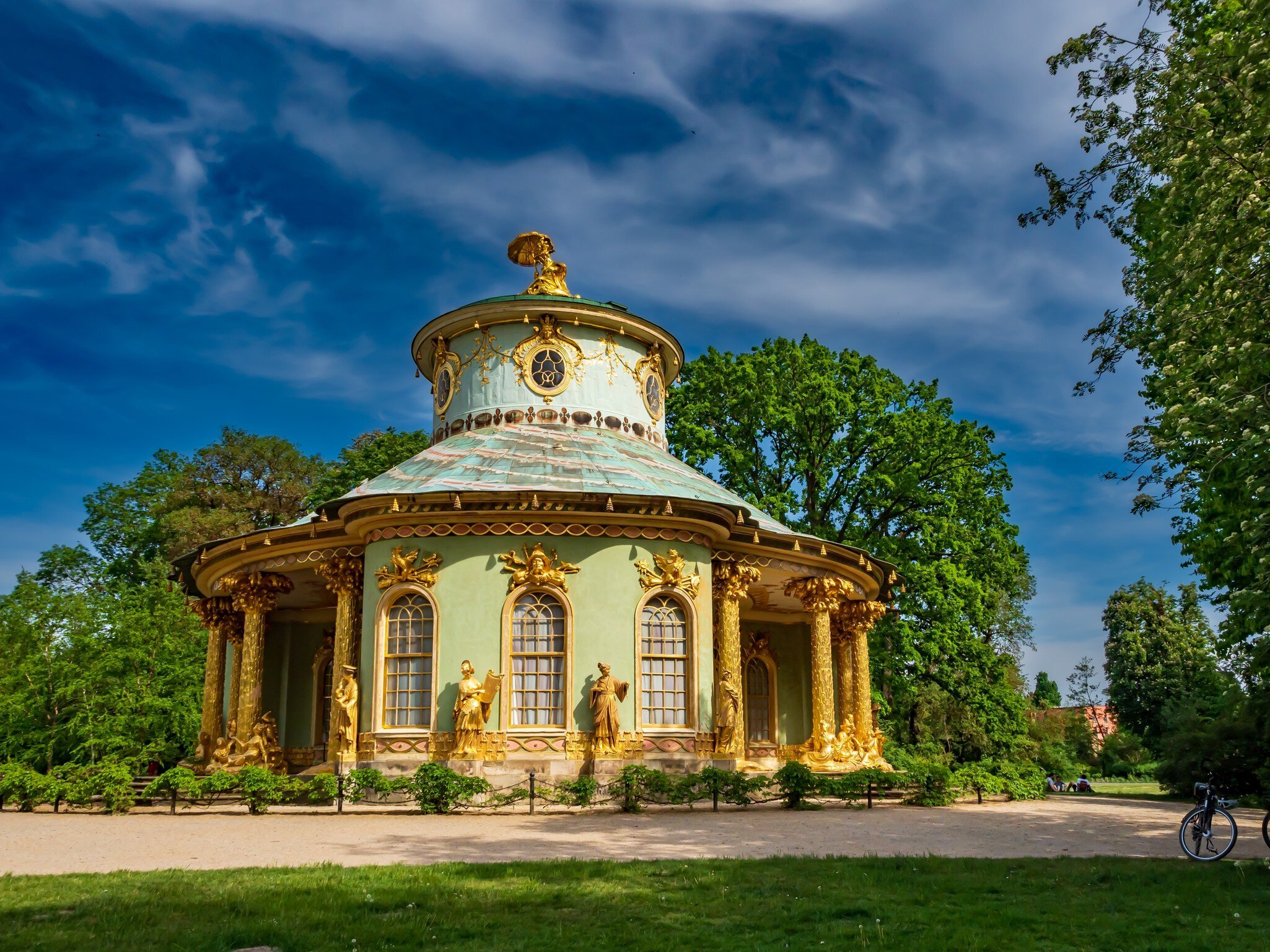 Exterior of Chinese tea house with golden statues, golden columns and golden window frames.