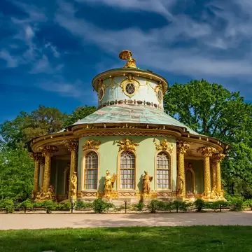 Exterior of Chinese tea house with golden statues, golden columns and golden window frames.