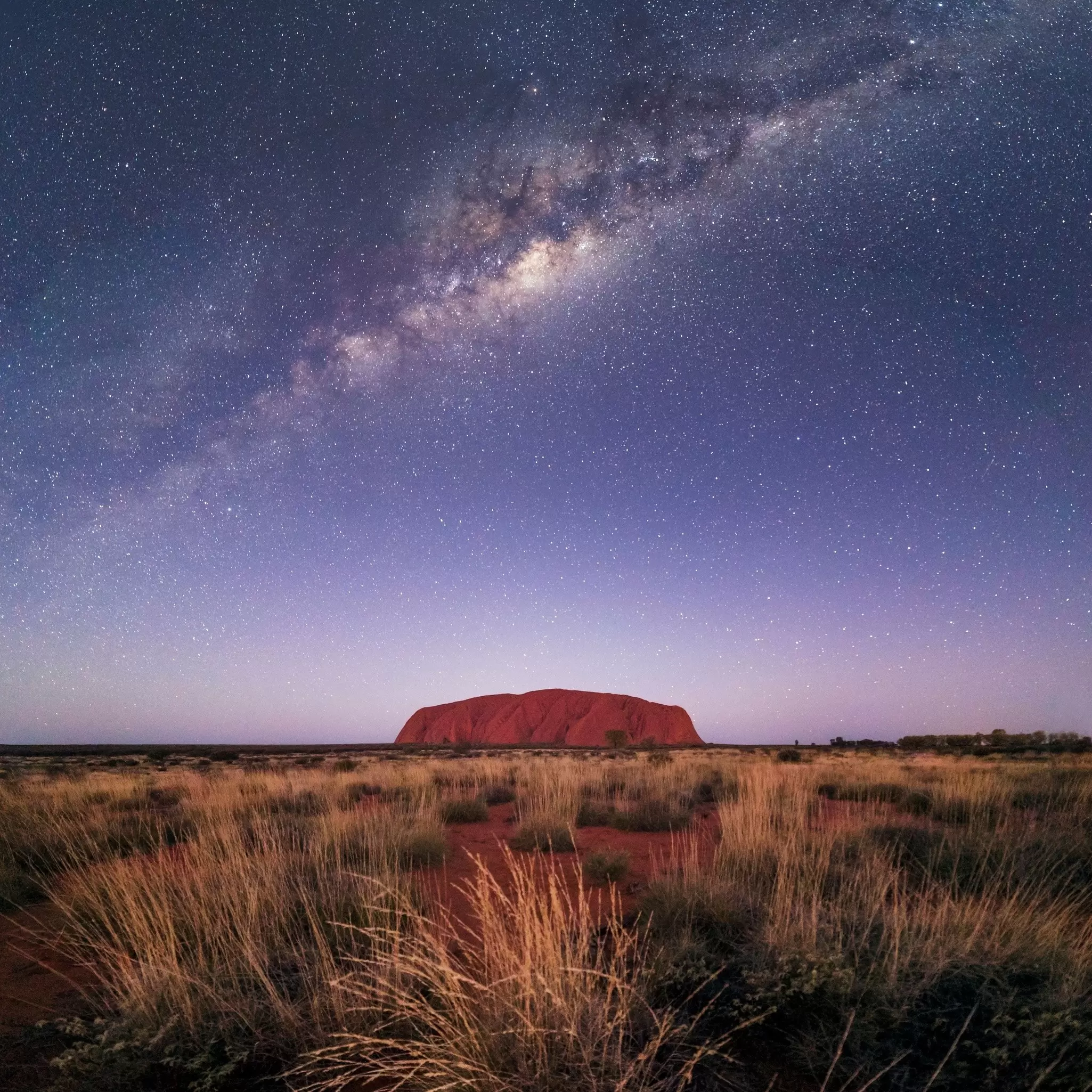 Uluṟu under the night sky from a distance 