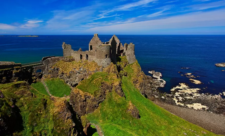 Ruins of Dunluce Castle on a grassy clifftop above the sea on the Causeway Coast, County Antrim, Northern Ireland