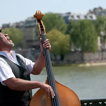 A double bassist belting out Jazz on the bank of the Seine, Paris. Christian Rummel / Getty Images