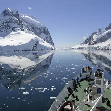 A small cruise ship makes passage through the Lemaire Channel in Antarctica