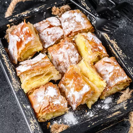 A basket with a flaky pastry filled with cream that's cut into squares.