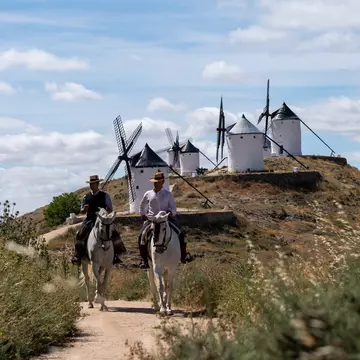 Spain has been taking strides to put sustainability at the forefront of its long-established tourism industry. Here, Miguel Angel and his brother Jesus ride their horses near the famed windmills of Castilla-La Mancha. Blake Horn for Lonely Planet