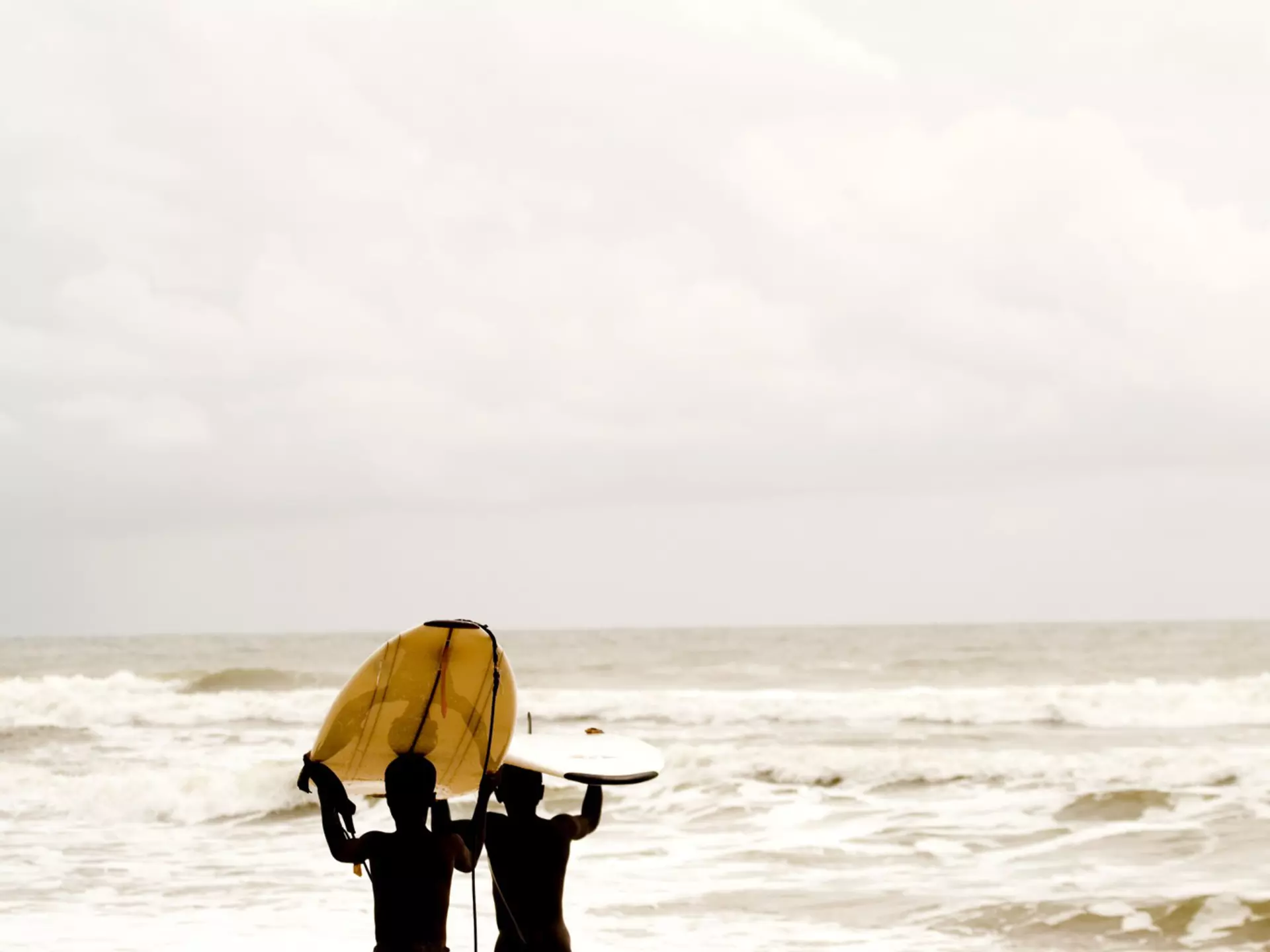 Liberia, Cape Mount, Robertsport, surfer walking on the beach
