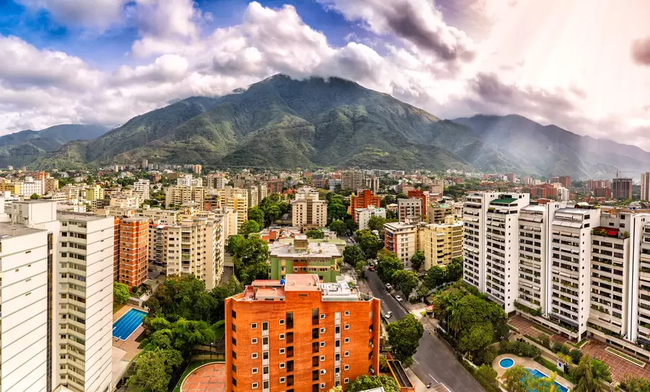 Caracas apartment towers and leafy streets spread below the green slopes of cloud-topped El Ávila mountain, Venezuela