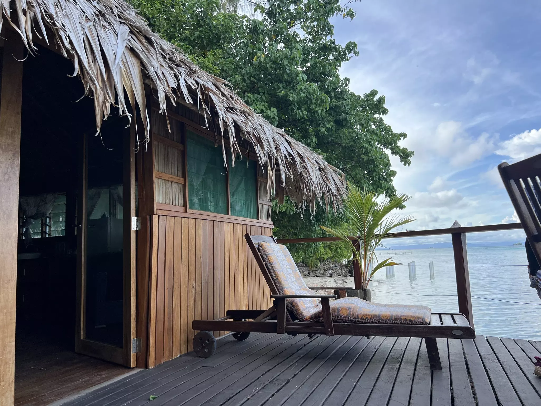 A sunlounger on the deck of an overwater bungalow